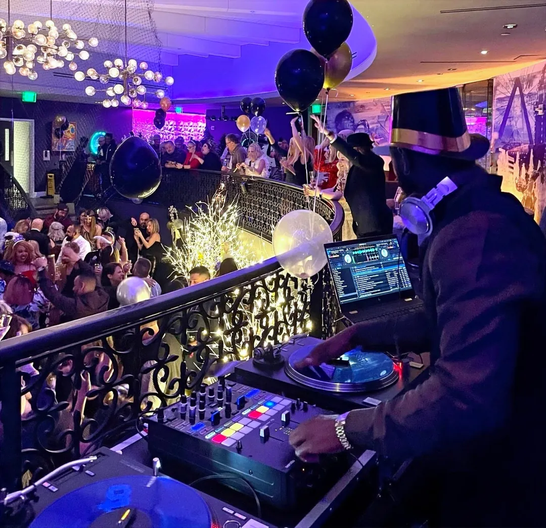Packed ballroom under a canopy of balloons