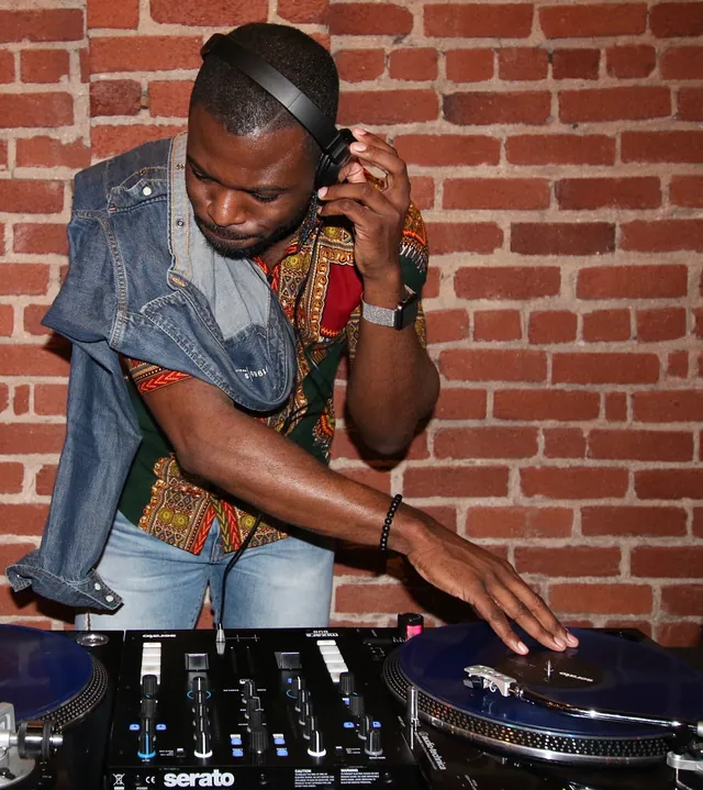 dj Darko cutting on the decks against an exposed brick wall